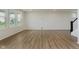 Spacious living room with wood floors, large windows, and a staircase with dark banister at 2705 Penn Ave, Plainfield, IN 46168