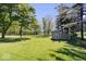 Spacious backyard with lush green grass, mature trees, and storage shed at 305 N 1100 E, Zionsville, IN 46077