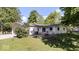 Rear exterior view features a patio with outdoor furniture, a fire pit, and a spacious backyard bordered by mature trees at 305 N 1100 E, Zionsville, IN 46077