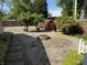 This charming backyard includes a decorative patio space, mature trees, and a custom shed at 309 Arlington Dr, Whiteland, IN 46184