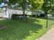 View of the home's side exterior and the front yard with a chain-link fence surrounding the property at 3161 Compass Dr, Franklin, IN 46131