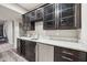 Basement bar featuring dark wood cabinetry, wine storage, stainless steel beverage center, and light granite countertops at 3316 Shelborne Woods Pkwy, Carmel, IN 46032