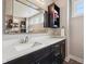 Modern bathroom with dark wood cabinets, quartz countertop, decorative mirror, and elegant fixtures at 3316 Shelborne Woods Pkwy, Carmel, IN 46032