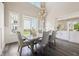 Bright dining area with hardwood floors, stylish lighting, and large windows providing beautiful outdoor views at 3316 Shelborne Woods Pkwy, Carmel, IN 46032
