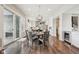 Open dining area with dark hardwood floors, modern light fixture and easy access to both kitchen and outdoor living area at 3316 Shelborne Woods Pkwy, Carmel, IN 46032