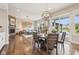 Open dining area with hardwood floors and a modern light fixture, connects the living room and outdoor living area at 3316 Shelborne Woods Pkwy, Carmel, IN 46032