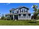 Charming two-story house features dark blue siding, white trim, black shutters, and a well-maintained front lawn at 3316 Shelborne Woods Pkwy, Carmel, IN 46032