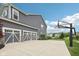 Spacious three-car garage with white doors and a paved driveway, with a basketball hoop on the side at 3316 Shelborne Woods Pkwy, Carmel, IN 46032