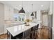 Bright kitchen features modern white cabinets, a large center island and stainless steel appliances at 3316 Shelborne Woods Pkwy, Carmel, IN 46032