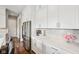 Modern white kitchen with stainless steel appliances, light countertops and beautiful tiled backsplash at 3316 Shelborne Woods Pkwy, Carmel, IN 46032
