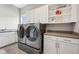 Bright laundry room featuring a front loading washer and dryer, white cabinets, and a gray countertop at 3316 Shelborne Woods Pkwy, Carmel, IN 46032