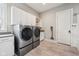Modern laundry room with front loading washer and dryer, ample white cabinetry, and gray countertops at 3316 Shelborne Woods Pkwy, Carmel, IN 46032