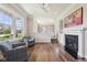 Cozy living room with a fireplace, hardwood floors, and large windows providing natural light at 3316 Shelborne Woods Pkwy, Carmel, IN 46032