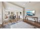 Bright open-concept living room with hardwood floors, a modern entertainment center and an open layout to the kitchen at 3316 Shelborne Woods Pkwy, Carmel, IN 46032