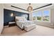 Elegantly designed main bedroom with a statement wall, tray ceiling, unique lighting, and a plush bench at 3316 Shelborne Woods Pkwy, Carmel, IN 46032