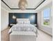 Elegantly designed main bedroom with a statement wall, tray ceiling, unique lighting, and a plush bench at 3316 Shelborne Woods Pkwy, Carmel, IN 46032
