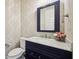 Elegant powder room featuring marble countertops, blue vanity, and decorative wallpaper at 3316 Shelborne Woods Pkwy, Carmel, IN 46032