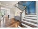 Elegant staircase with wooden banister and a striking blue accent wall at 3316 Shelborne Woods Pkwy, Carmel, IN 46032