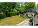 A spacious backyard featuring a patio with outdoor seating, a lush lawn, and mature trees offering plenty of shade at 410 Somerset W Dr, Indianapolis, IN 46260