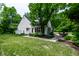 View of the home's backyard with lush lawn and mature trees at 410 Somerset W Dr, Indianapolis, IN 46260