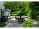 A backyard patio features an outdoor dining set under a lush green canopy at 410 Somerset W Dr, Indianapolis, IN 46260