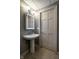 Clean bathroom features a pedestal sink with large mirror and tiled floor at 410 Somerset W Dr, Indianapolis, IN 46260