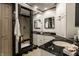 A modern bathroom with dual sinks, black countertops, and a walk-in shower at 410 Somerset W Dr, Indianapolis, IN 46260
