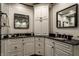 Bathroom featuring white cabinets, black countertops, double sinks and decorative wall mirror at 410 Somerset W Dr, Indianapolis, IN 46260
