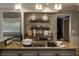 Open kitchen with stainless refrigerator, wooden cabinets, granite countertops, and modern lighting at 410 Somerset W Dr, Indianapolis, IN 46260