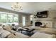 Spacious living room featuring brick fireplace, and large windows offering natural light at 410 Somerset W Dr, Indianapolis, IN 46260