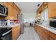 Bright kitchen with stainless steel refrigerator and appliances, wooden cabinets, and tile floor at 4232 Linden Ln, Anderson, IN 46011