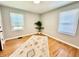 Bright bedroom with hardwood floors, two windows, neutral walls and decorative rug and plant at 4714 Crestview Ave, Indianapolis, IN 46205