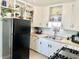Bright kitchen featuring white cabinets, a black refrigerator and a stainless-steel sink at 4714 Crestview Ave, Indianapolis, IN 46205