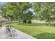 Well-manicured backyard featuring a patio, green grass, mature trees and a wood fence at 4818 Arabian Run, Indianapolis, IN 46228