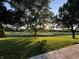 A beautiful backyard view with a lush lawn, mature trees, and a glimpse of the golf course beyond the wooden fence at 4818 Arabian Run, Indianapolis, IN 46228