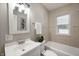 Bathroom featuring tiled walls, shower-tub, and vanity sink with modern lighting at 5232 E 10Th St, Indianapolis, IN 46219