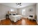 Bright bedroom with a modern ceiling fan, a large headboard, and hardwood floors at 5232 E 10Th St, Indianapolis, IN 46219