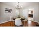 Dining room featuring hardwood floors, modern chandelier, and a view into the adjacent kitchen at 5232 E 10Th St, Indianapolis, IN 46219