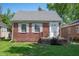 Charming brick home with a well-maintained lawn and white-trimmed windows on a sunny day at 5232 E 10Th St, Indianapolis, IN 46219
