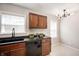 Modern kitchen with dark wood cabinets, black countertop, and a stainless steel sink at 5232 E 10Th St, Indianapolis, IN 46219