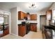 Well-lit kitchen with dark wood cabinets, black appliances, and tiled flooring at 5232 E 10Th St, Indianapolis, IN 46219