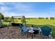 Inviting backyard with a swing set, fire pit, and blue Adirondack chairs at 5560 Goodwin St, Indianapolis, IN 46234