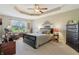 The bedroom offers a tray ceiling, carpeted floor, a ceiling fan, and a seating area by a window at 5560 Goodwin St, Indianapolis, IN 46234