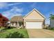 Single-story home with a brick facade, an attached garage, and a well-manicured front lawn under a blue sky at 5560 Goodwin St, Indianapolis, IN 46234