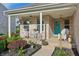 Inviting front porch with decorative seating, hanging plants, and a charming turquoise front door at 5560 Goodwin St, Indianapolis, IN 46234