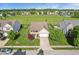 Aerial view of home featuring manicured lawn, mature trees, attached garage, and welcoming front porch at 5560 Goodwin St, Indianapolis, IN 46234