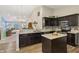 Open kitchen features dark cabinetry, tile backsplash, laminate countertops, and wood look flooring at 5560 Goodwin St, Indianapolis, IN 46234