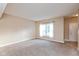 Neutral-toned living room featuring new carpet and a bright window with white curtains at 5891 Mimosa Dr, Indianapolis, IN 46234
