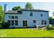 Back exterior of a two-story home with a well-manicured lawn, patio, and a swing at 6056 Blackley Ct, Indianapolis, IN 46254