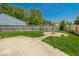 Fenced back yard has a concrete patio, gravel firepit area and view of a neighborhood playground at 6213 Selago Dr, Indianapolis, IN 46203